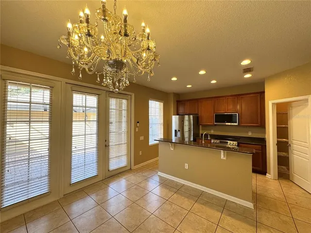 a large kitchen with kitchen island granite countertop a refrigerator a stove top oven a sink and dishwasher