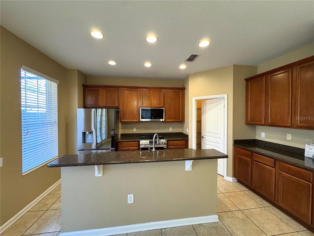 7752 Moser Avenue Windermere, FL 34786 - Photo 8 of 22 a kitchen with stainless steel appliances granite countertop a refrigerator sink and cabinets