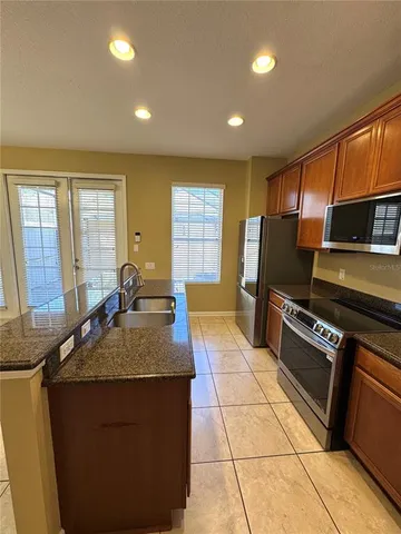a kitchen with stainless steel appliances granite countertop a stove a sink and a microwave
