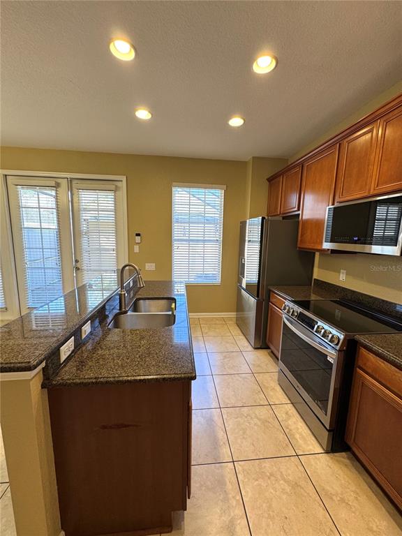 7752 Moser Avenue Windermere, FL 34786 - Photo 9 of 22 a kitchen with stainless steel appliances granite countertop a stove a sink and a microwave