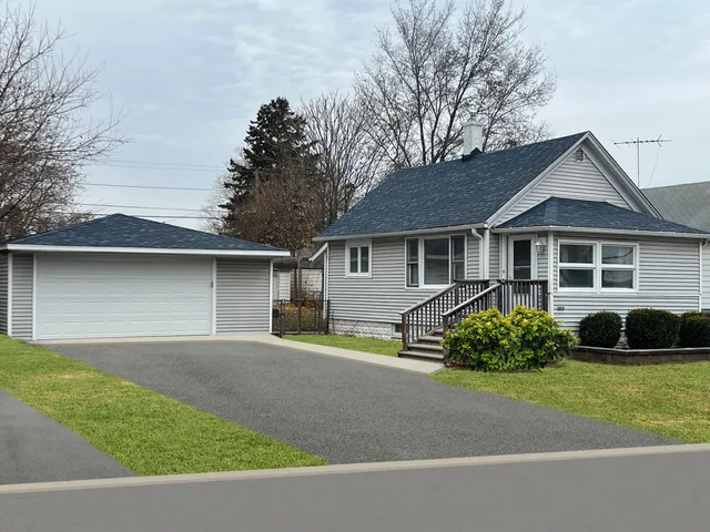 a front view of a house with a garden and plants
