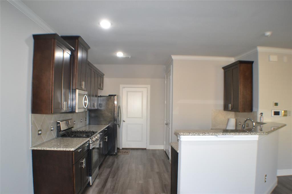 545 Teton Street Allen, TX 75002 - Photo 6 of 19 a kitchen with granite countertop cabinets a sink and stainless steel appliances