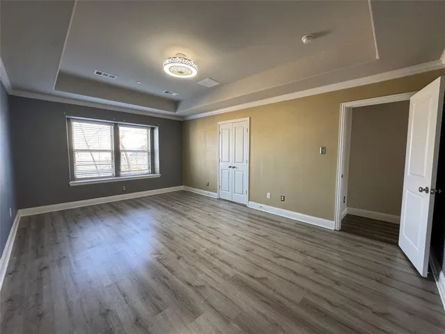 an empty room with wooden floor and window