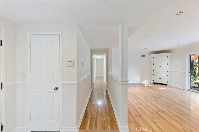 a view of a hallway with closet and wooden floor