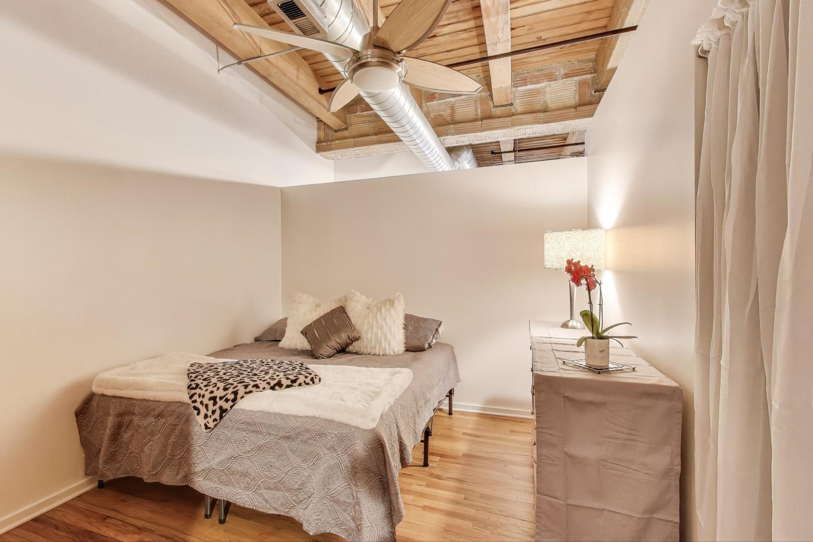 2310 South Canal Street, Unit 210 Chicago, IL 60616 - Photo 15 of 22 a bedroom with a bed and a chandelier