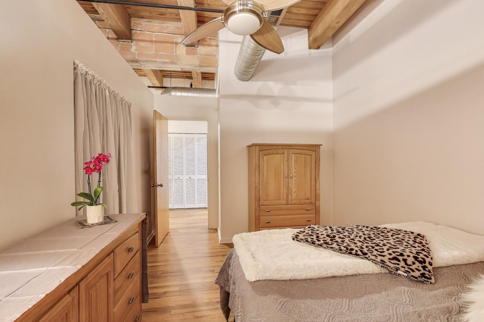 2310 South Canal Street, Unit 210 Chicago, IL 60616 - Photo 16 of 22 a bedroom with a bed and a chandelier