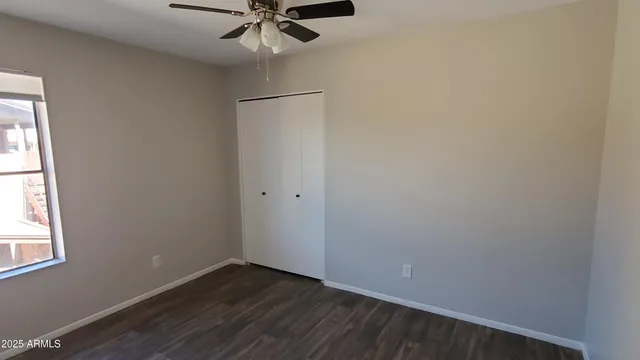 an empty room with a window and a fan