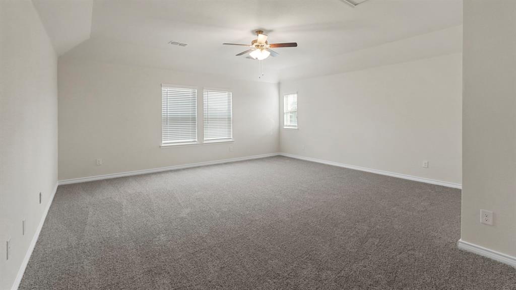 447 Epiphany Lane Lavon, TX 75166 - Photo 27 of 31 Spacious room featuring gray carpet, light-toned walls, and a ceiling fan with integrated lighting