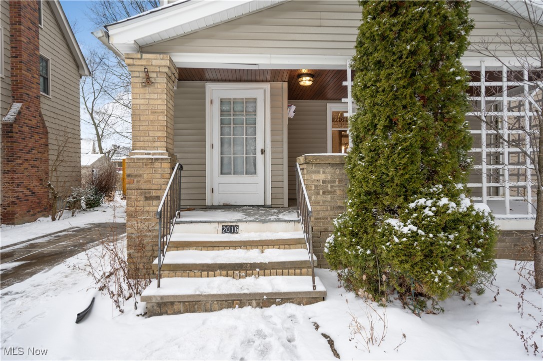 2016 Rossmoor Road Cleveland Heights, OH 44118 - Photo 4 of 46 Snow covered property entrance featuring a porch and brick siding