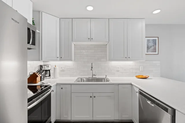 a kitchen with stainless steel appliances a sink stove and cabinets