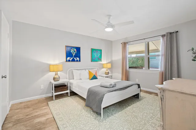 a bedroom with a bed wooden floor and window