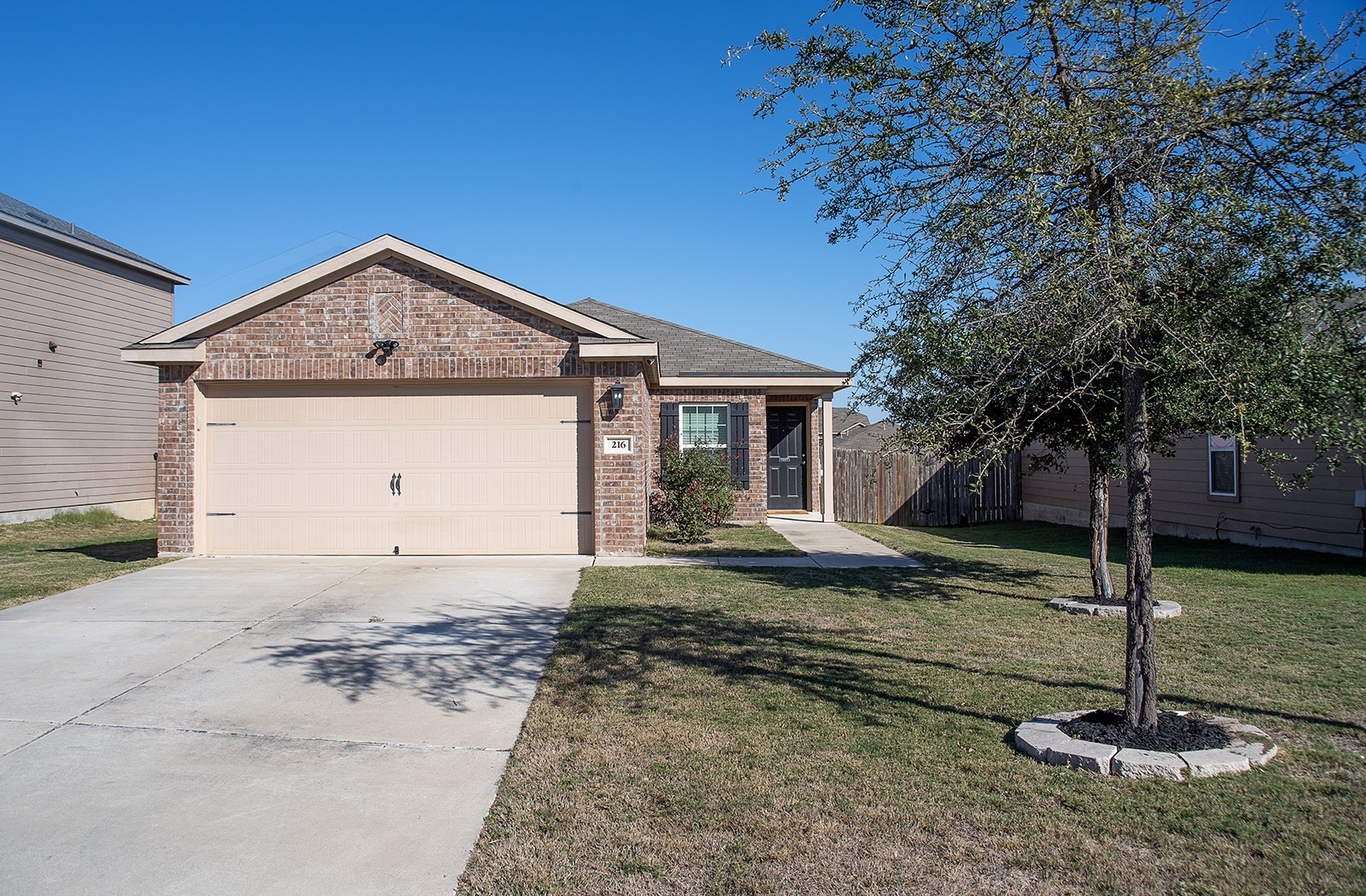 216 Millers Loop Jarrell, TX 76537 - Photo 2 of 31 Ranch-style home featuring brick siding, concrete driveway, and a garage