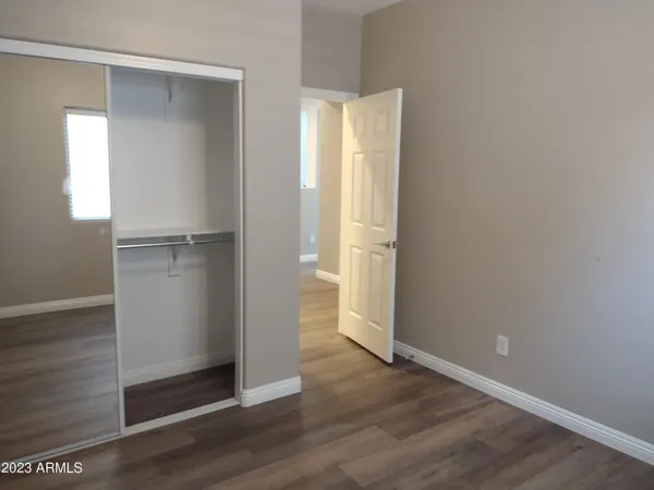an empty room with wooden floor and entrance