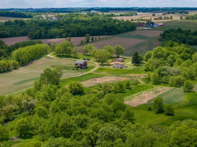 an aerial view of green landscape with trees houses and lake view