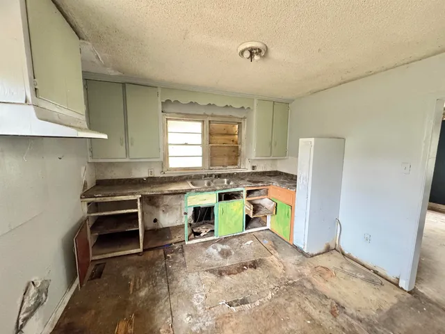 a kitchen with a stove a refrigerator and a window