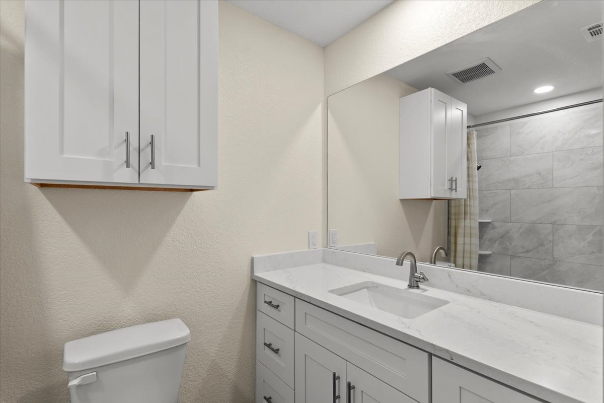 412 Oak Street Bastrop, TX 78602 - Photo 16 of 25 a bathroom with a granite countertop toilet sink and mirror