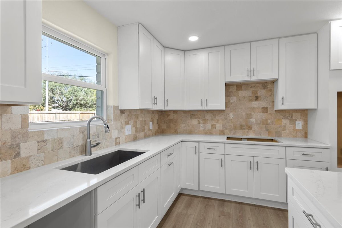 412 Oak Street Bastrop, TX 78602 - Photo 4 of 25 a kitchen with white cabinets white appliances sink and window