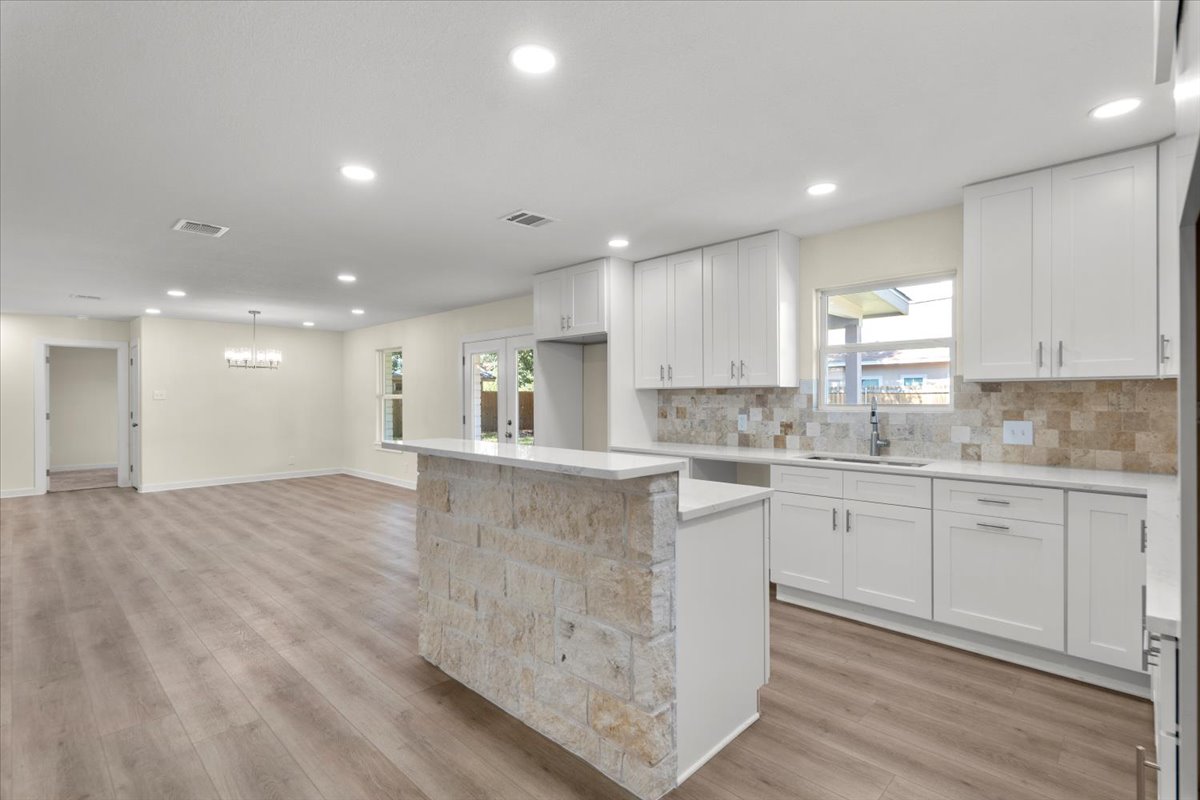 412 Oak Street Bastrop, TX 78602 - Photo 6 of 25 a large kitchen with stainless steel appliances granite countertop a large counter top and a stove with wooden floor