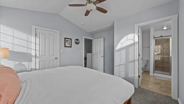 a bedroom with a large bed closet and chandelier