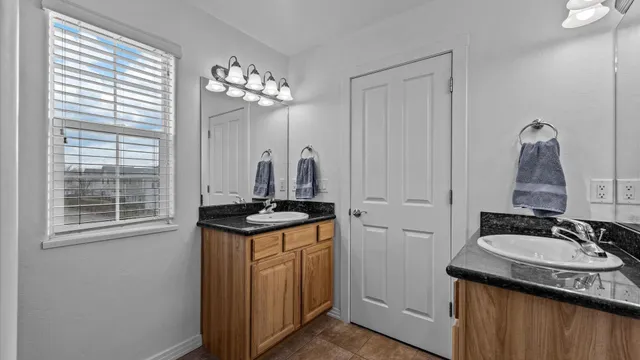 a bathroom with sinks granite countertop a sink and a washing machine
