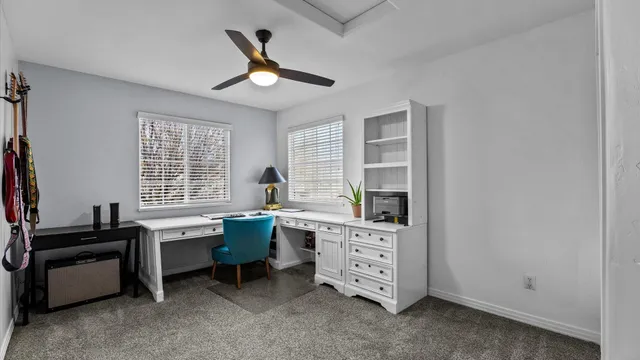 a view of a workspace with furniture and a window