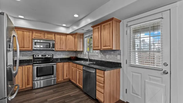a kitchen with granite countertop a stove top oven and sink
