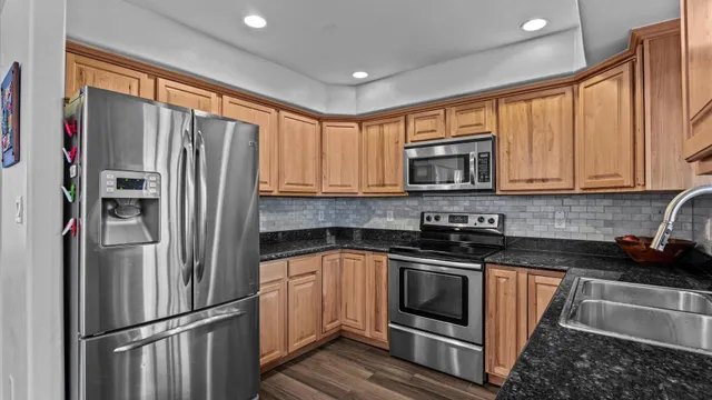 a kitchen with stainless steel appliances granite countertop a refrigerator stove microwave and sink