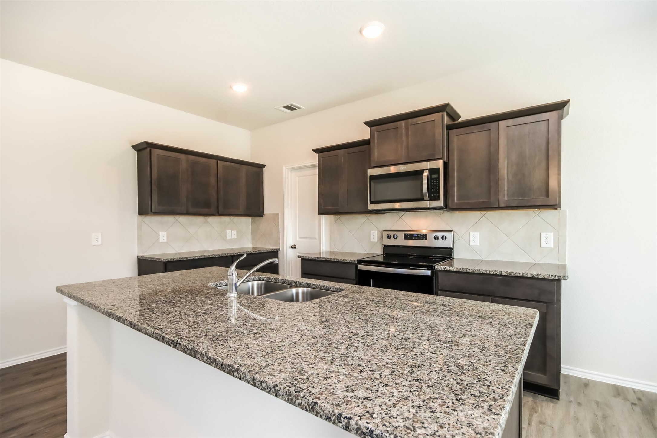 15226 Estrella Road West Houston, TX 77073 - Photo 3 of 13 a kitchen with stainless steel appliances granite countertop a sink microwave and stove