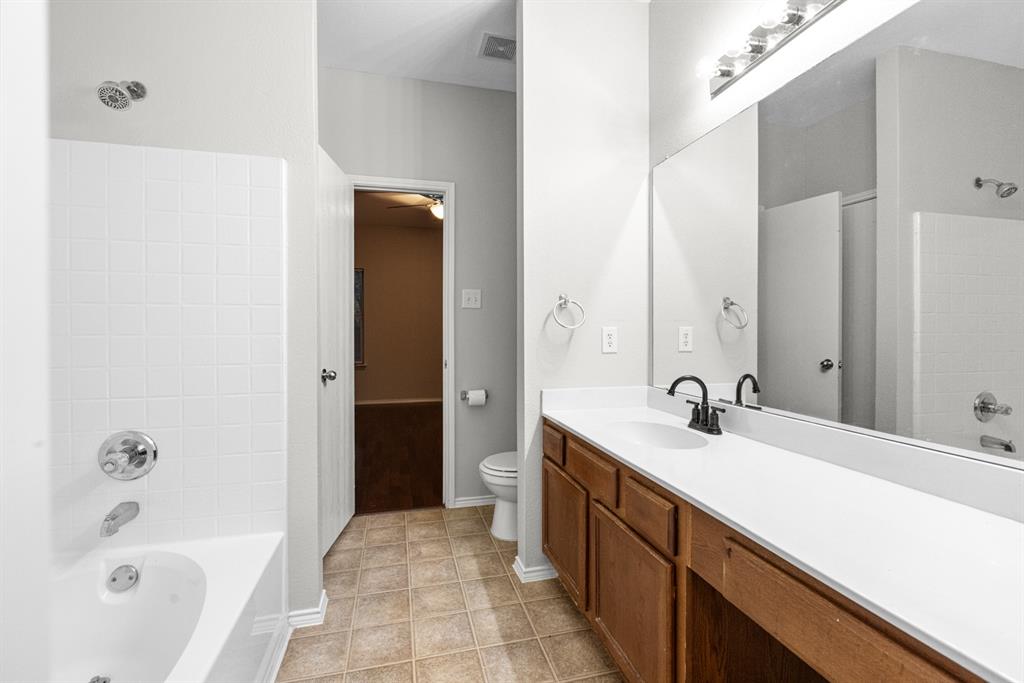 3521 Apple Valley Way Dallas, TX 75227 - Photo 11 of 25 a bathroom with a sink a mirror and a bathtub