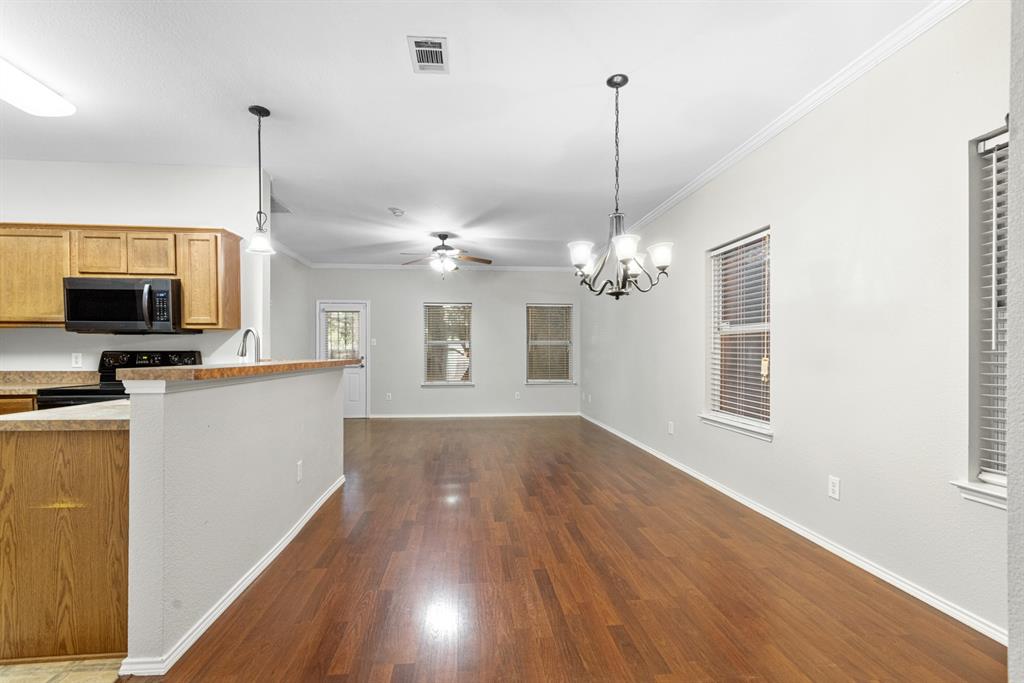 3521 Apple Valley Way Dallas, TX 75227 - Photo 4 of 25 a view of a kitchen with microwave and wooden floor