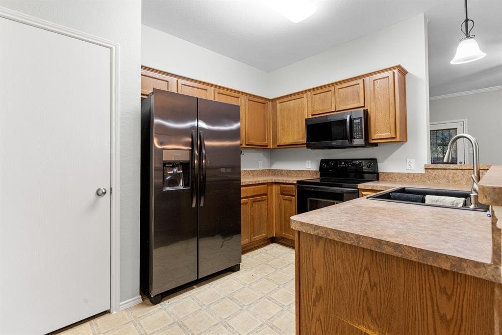 3521 Apple Valley Way Dallas, TX 75227 - Photo 5 of 25 a kitchen with stainless steel appliances a refrigerator stove and microwave