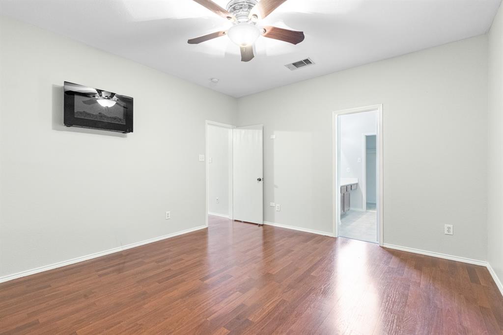 3521 Apple Valley Way Dallas, TX 75227 - Photo 10 of 25 a view of an empty room with wooden floor and a ceiling fan