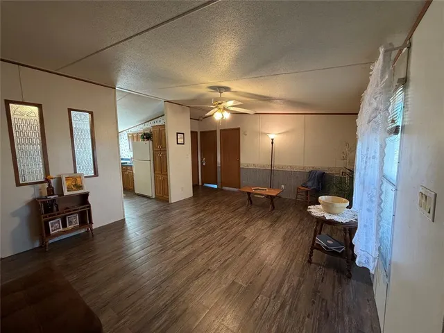 a view of a hallway with wooden floor and furniture