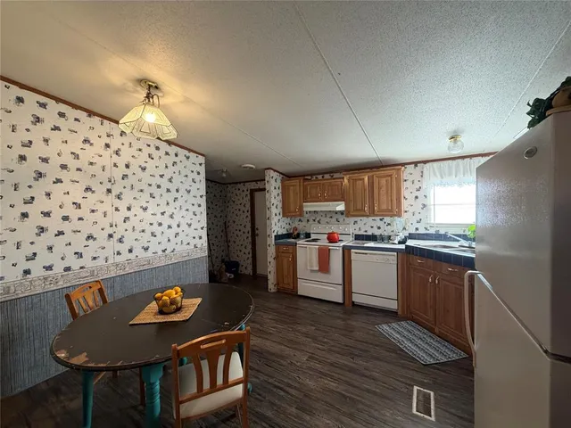 a kitchen with granite countertop a refrigerator and a stove