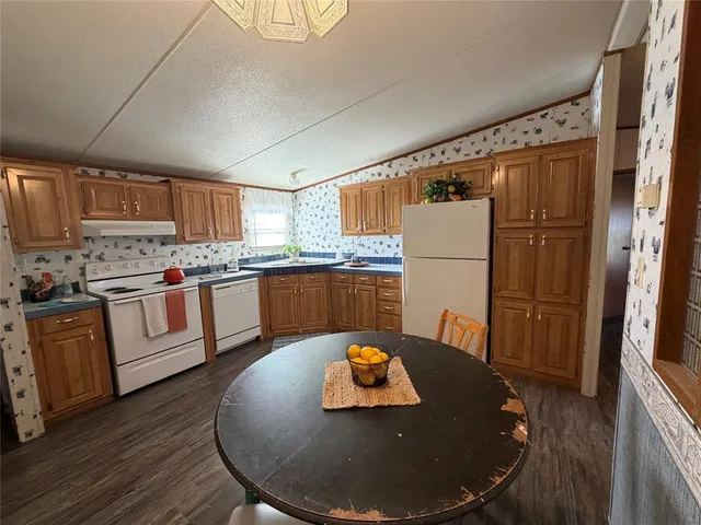 a kitchen with stainless steel appliances granite countertop a refrigerator a stove top oven a sink and cabinets