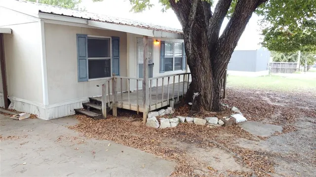 a view of a house with backyard and a tree