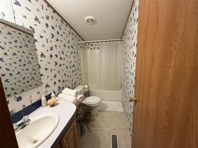 an aerial view of a house with lots of residential buildings ocean and mountain view in back