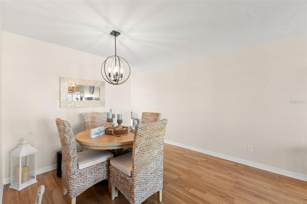 2461 Canadian Way, Unit 27 Clearwater, FL 33763 - Photo 26 of 35 a dining room with a wooden table and chairs