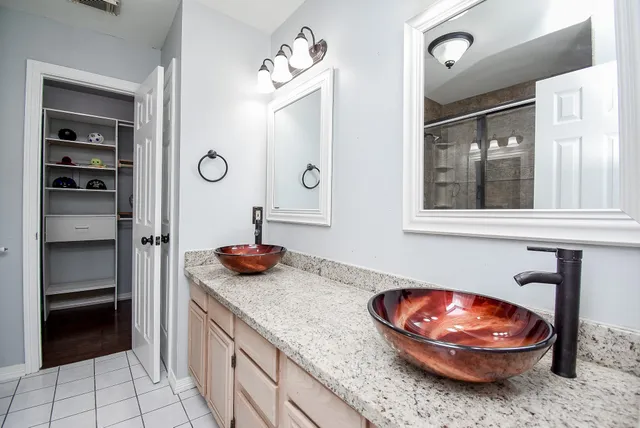 a bathroom with a granite countertop sink a toilet and shower