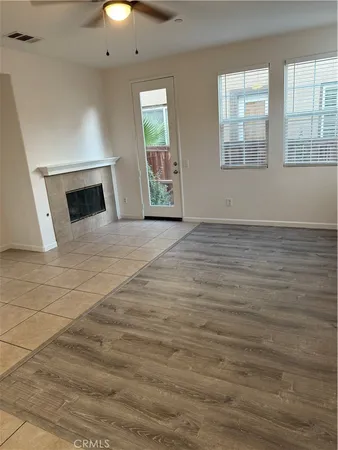 en empty room with windows and fireplace