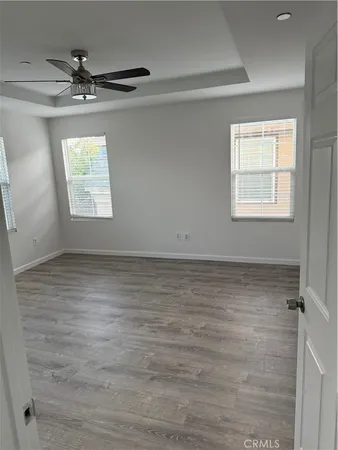 an empty room with a ceiling fan and window