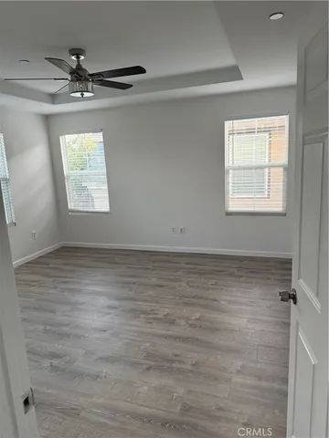 an empty room with a ceiling fan and window