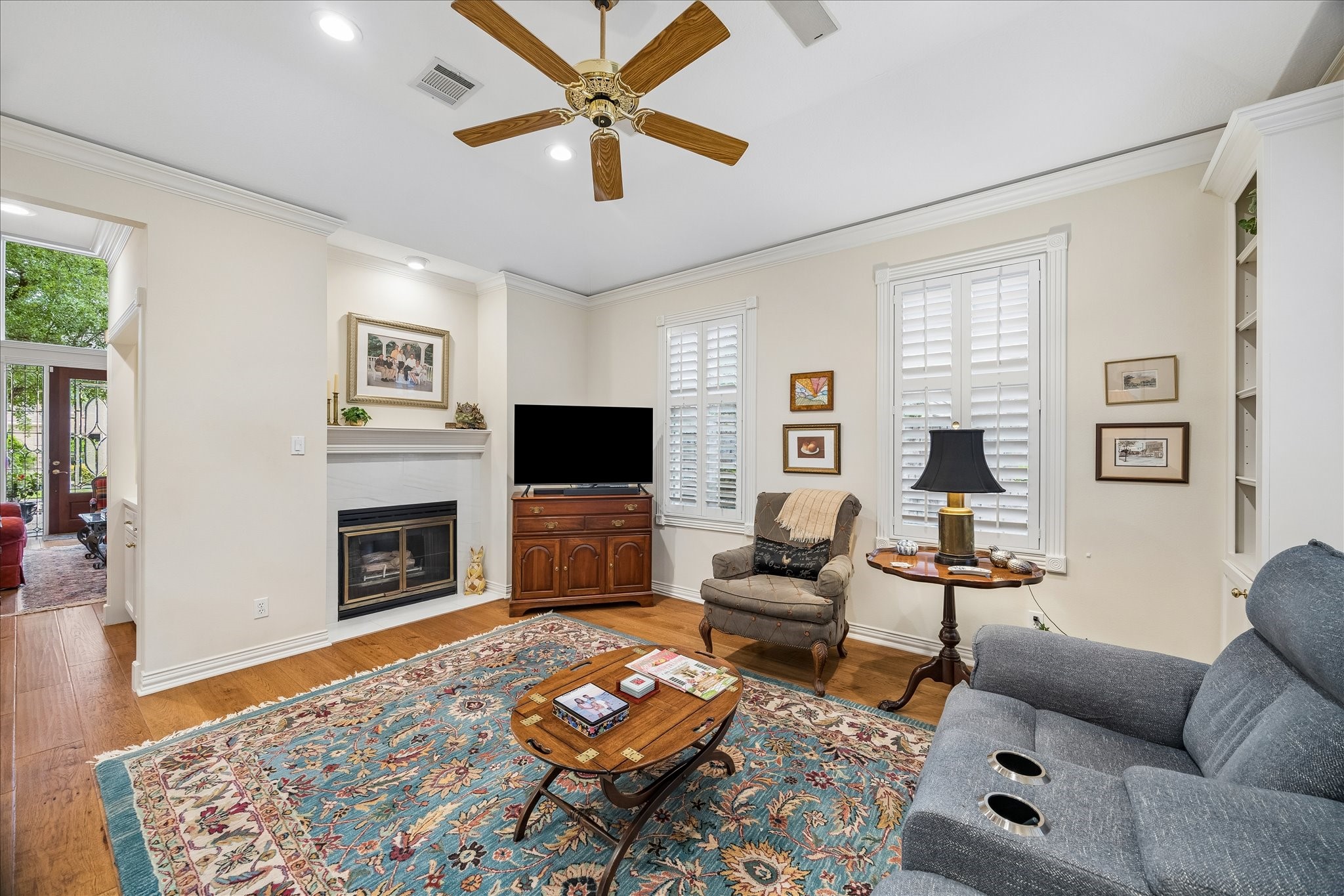 6611 Trebeck Lane Spring, TX 77379 - Photo 12 of 33 Inviting family room with cozy fireplace, warm wood flooring, and abundant natural light, creating a comfortable space to relax and unwind.