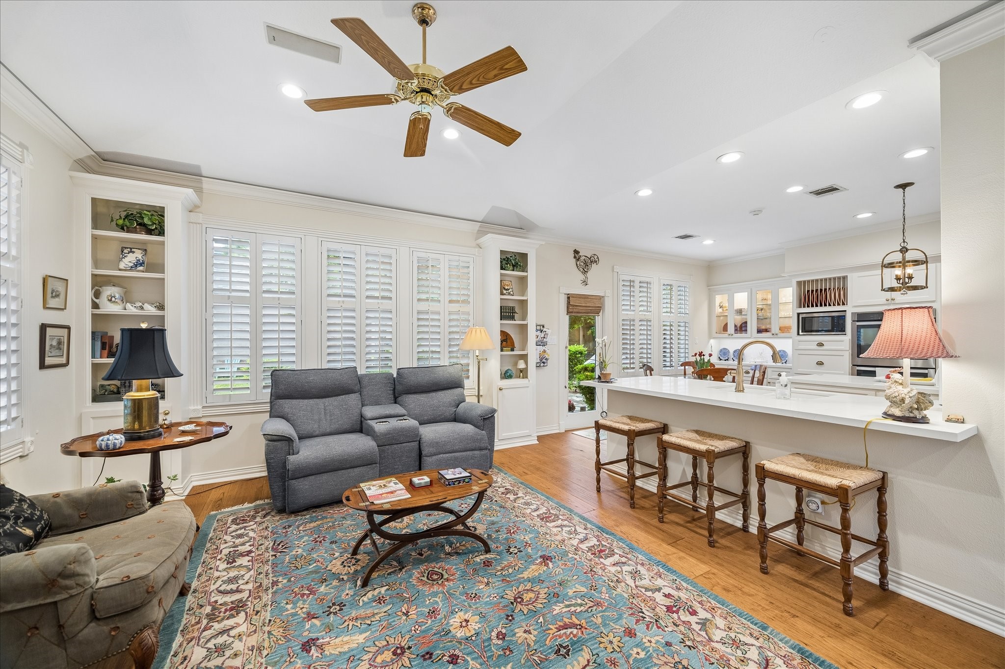 6611 Trebeck Lane Spring, TX 77379 - Photo 14 of 33 Open-concept family room seamlessly connects to the kitchen, featuring plantation shutters, built-ins, and a spacious layout ideal for everyday living.
