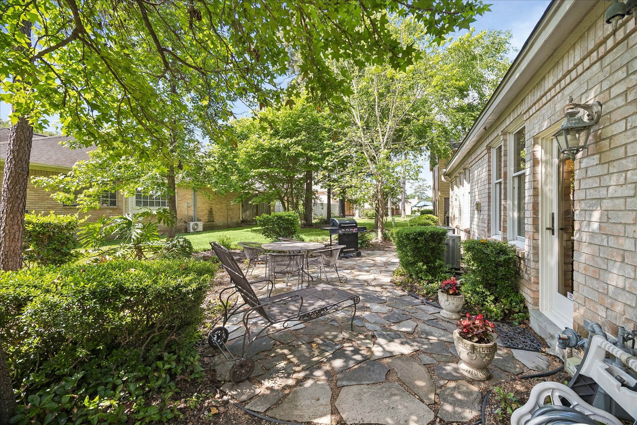 6611 Trebeck Lane Spring, TX 77379 - Photo 30 of 33 Outdoor patio surrounded by mature landscaping, offering a peaceful setting for relaxing.