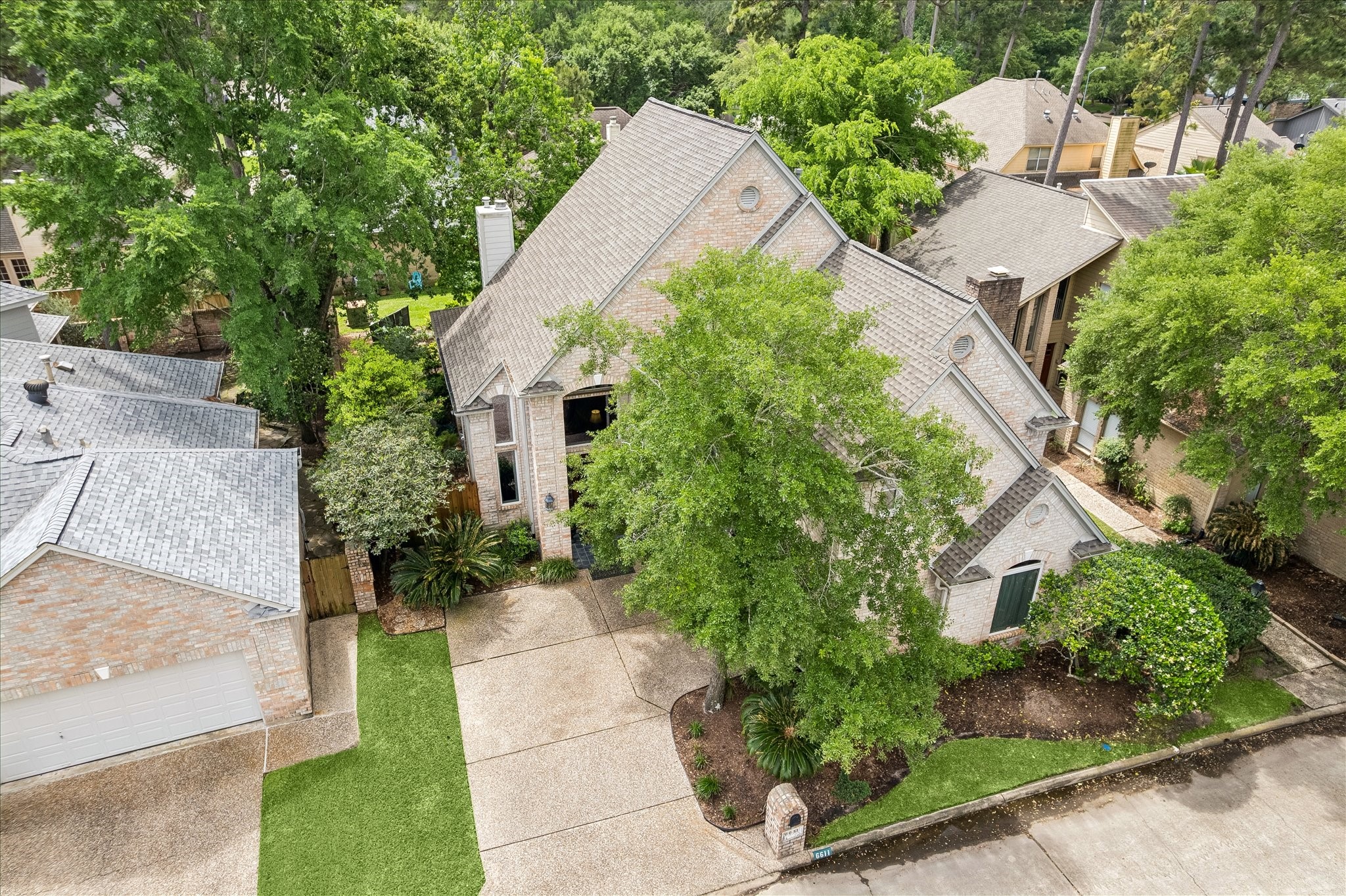 6611 Trebeck Lane Spring, TX 77379 - Photo 31 of 33 Beautifully maintained brick home nestled on a quiet street, surrounded by mature trees and lush landscaping, offering timeless curb appeal.
