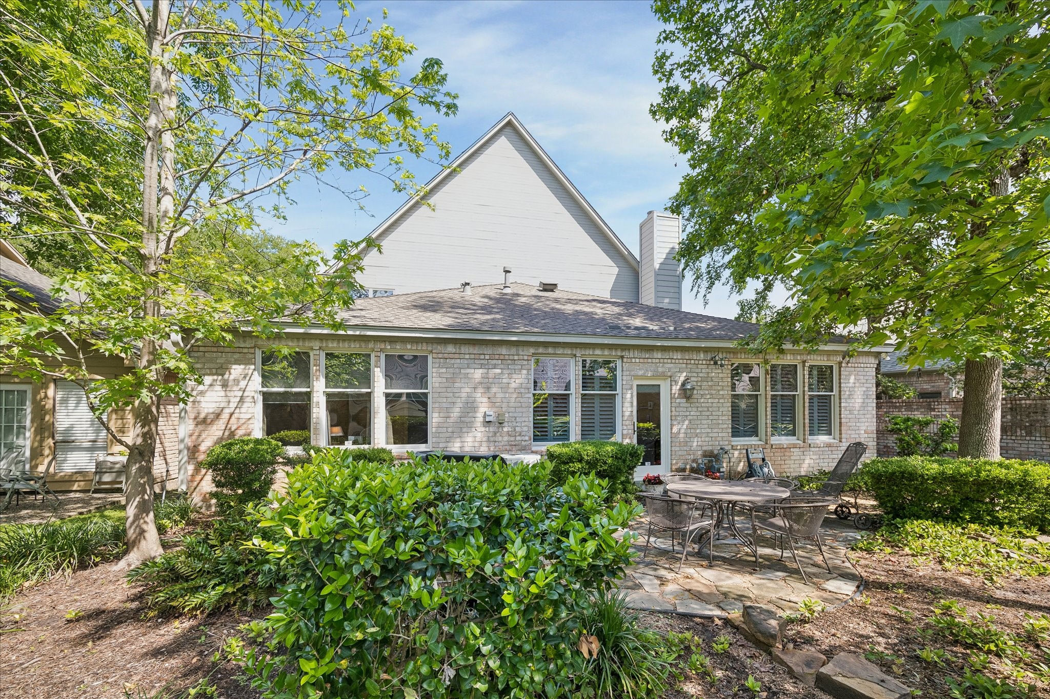 6611 Trebeck Lane Spring, TX 77379 - Photo 5 of 33 Beautifully landscaped with lush greenery, stone patio, and ample space to enjoy outdoor living.