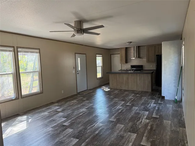 a view of kitchen with sink microwave refrigerator and cabinets