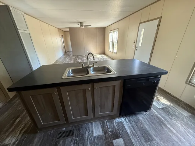 a bathroom with a sink a mirror and wooden floor