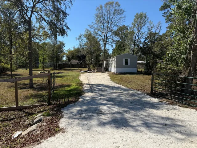 a view of a yard with wooden fence